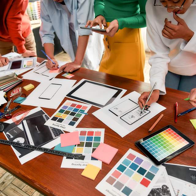 Simpleview Creative Services - Team of people around a desk, working on creative design project
