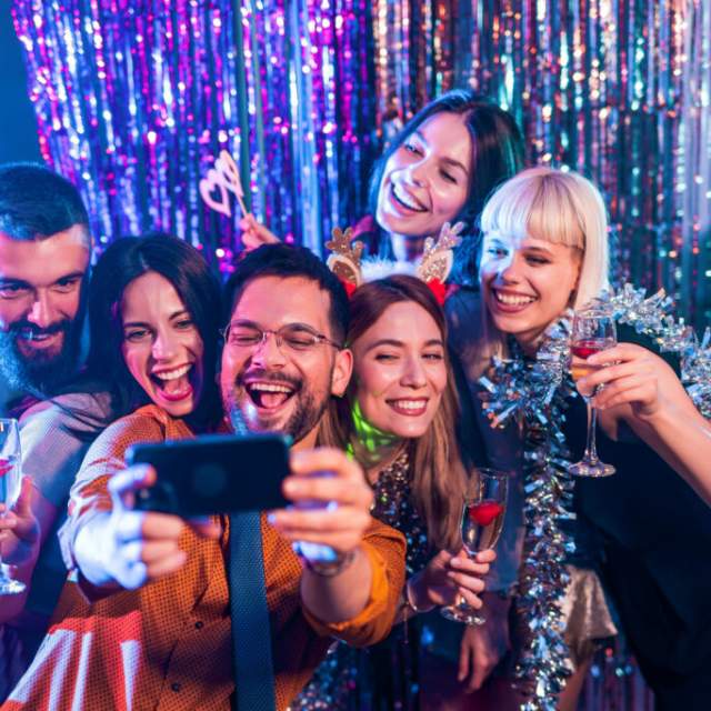 People posing for a selfie at a party.