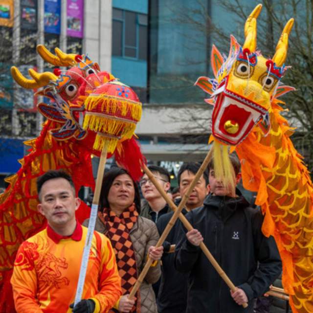 Group of people holding sticks up to carry the Lunar New Year dragons