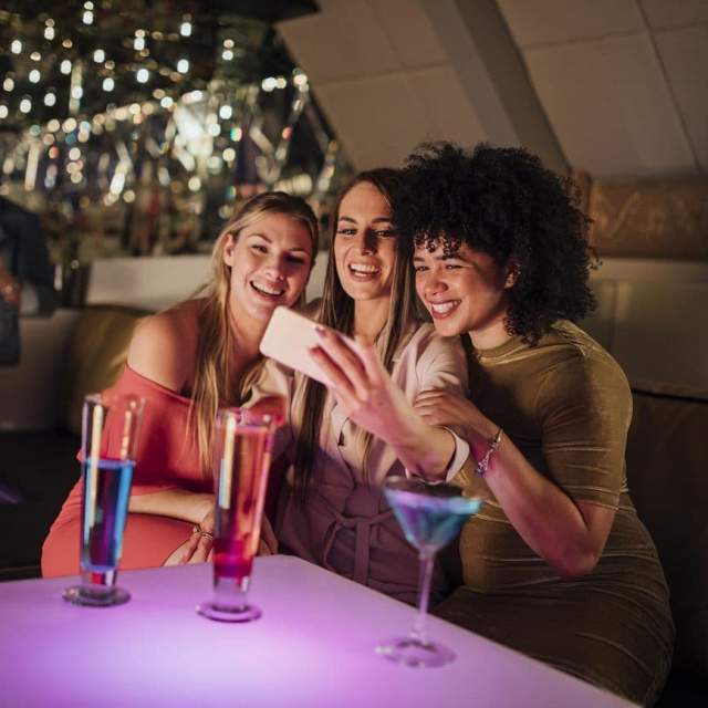 Three ladies taking a selfie in a nightclub