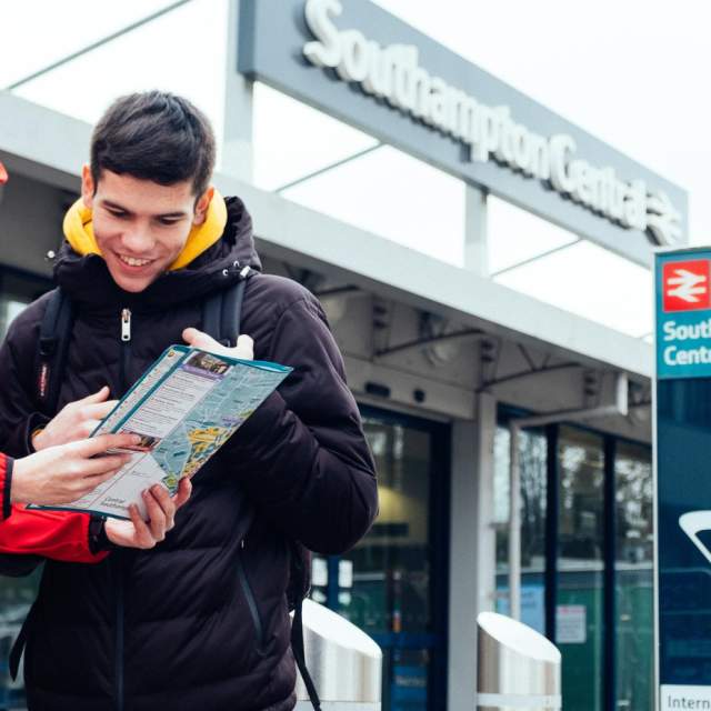 Two people looking down at a map outside Southampton Central Train Station