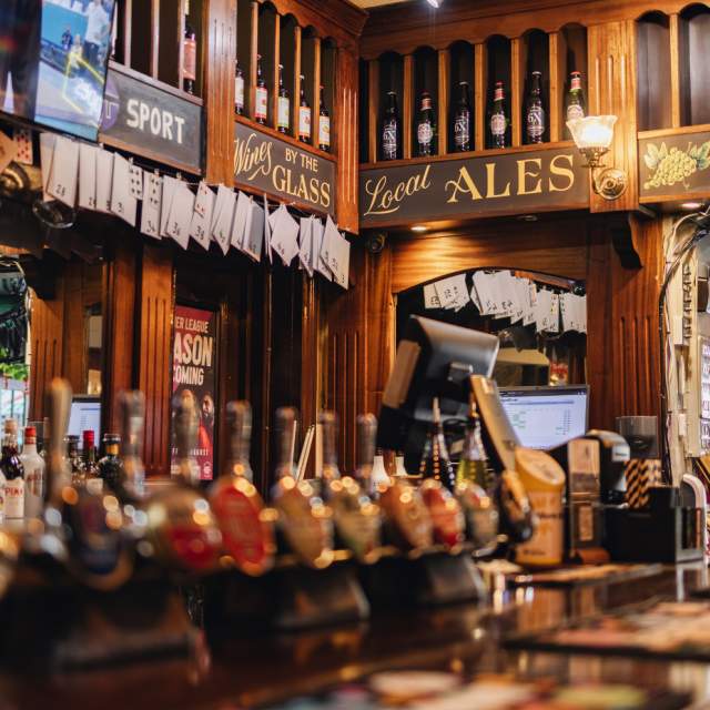 Front of traditional pub bar showing beer pumps
