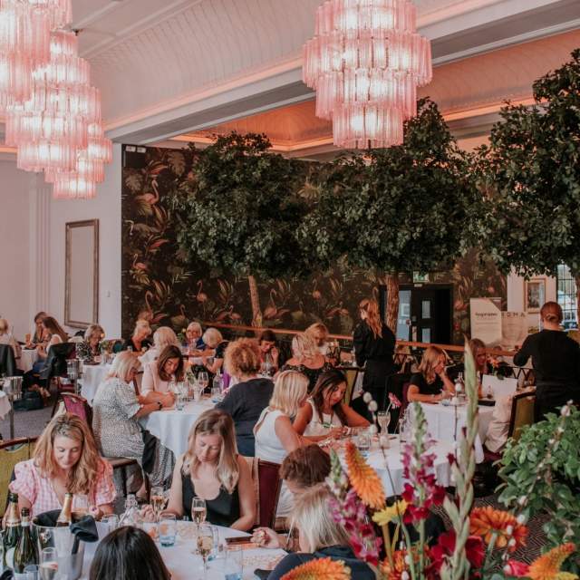 Groups of women dining at large round tables at The Grand