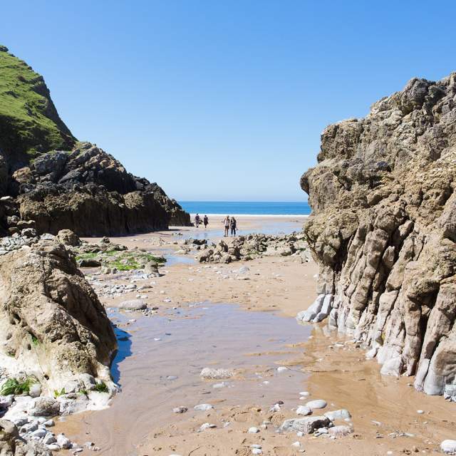 People walking across Mewslade Bay