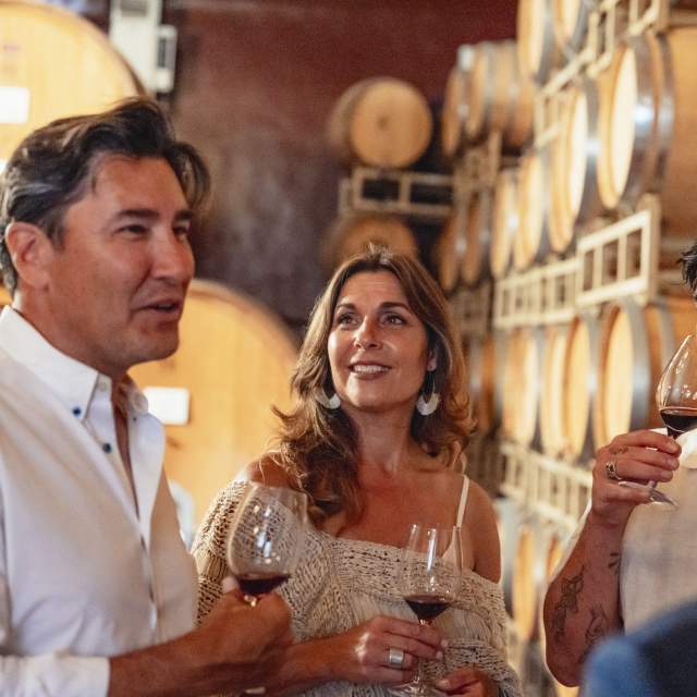 Couple and a few friends wine tasting in the barrel room at Ponte Vineyard in Temecula