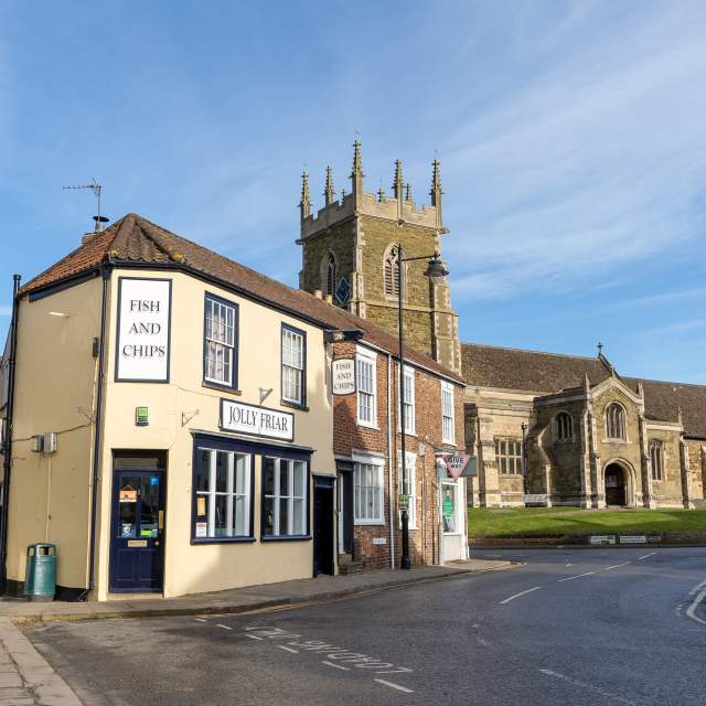 A church and fish and chip shop street under blue skies