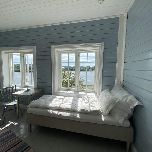 Soverom med seng og to vinduer