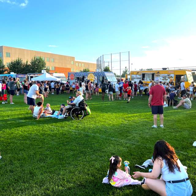 4th of July event attendees enjoying food truck food on the Sports Center lawn prior to the fireworks