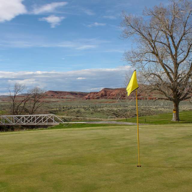 Lush green fairway at the Thermopolis Golf Course with rolling hills in Hot Springs County, Wyoming.
