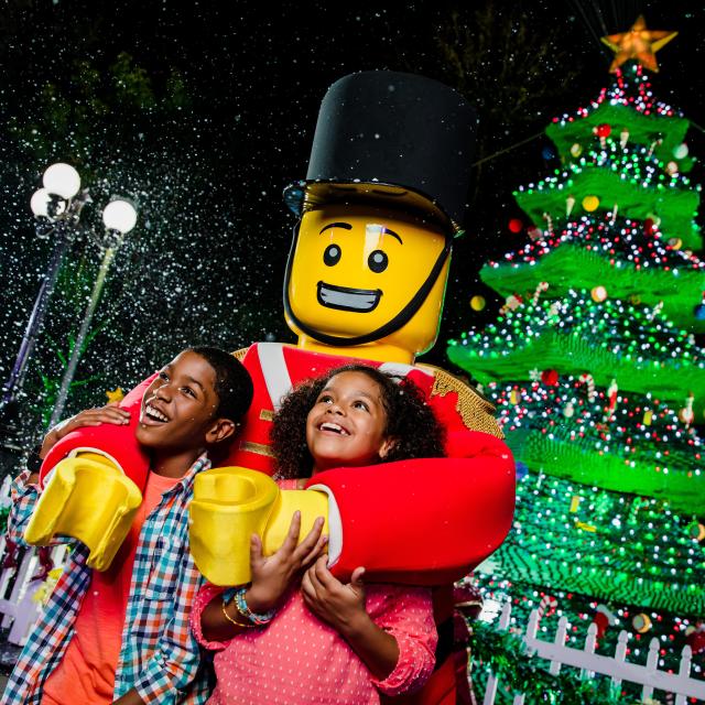 Kids pose with a toy soldier at Christmas Bricktacular at Legoland Florida Resort