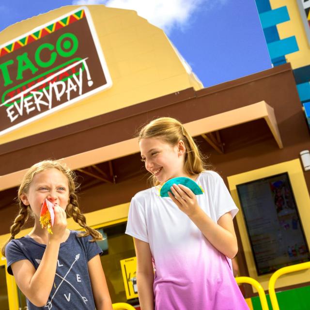 Kids eating outside the Taco Everyday restaurant at LEGO MOVIE WORLD.