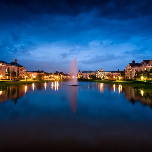 Disney's Saratoga Springs Resort & Spa exterior with lake in foreground at evening