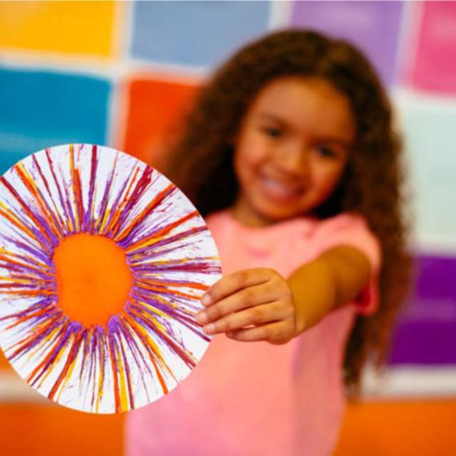 Girl showing off drip art Crayola Experience Orlando