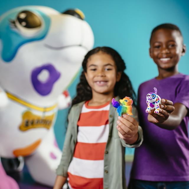 A boy and a girl show off their Scribble Scrubbies creations at Crayola Experience Orlando