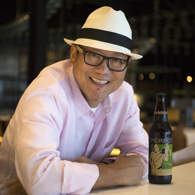 Chef Morimoto leaning on a bar at Morimoto Asia at Disney Springs.