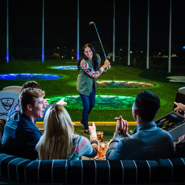 Topgolf group playing golf at night