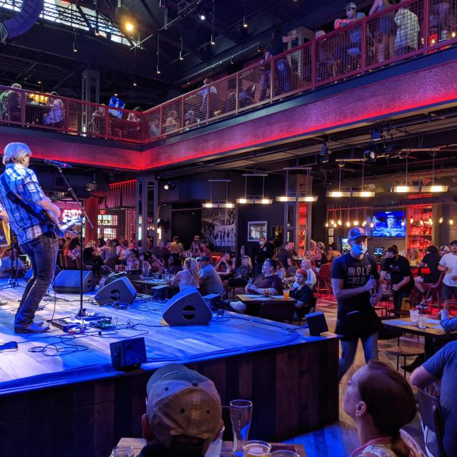 A band performs in front of an audience at Ole Red at Icon Park, in Orlando, Florida