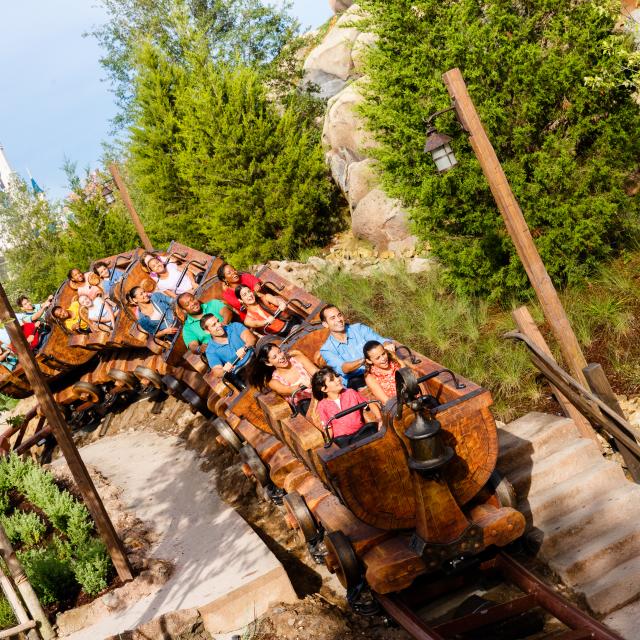 Guests riding the Seven Dwarfs Mine Train at Walt Disney World's Magic Kingdom Park