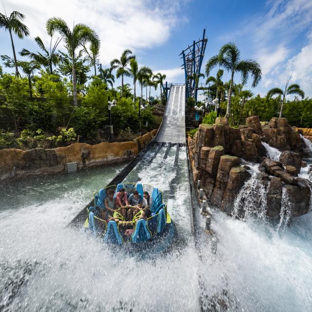 A water-soaked family rides Infinity Falls raft ride at SeaWorld Orlando.