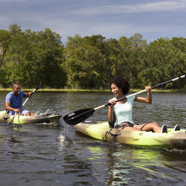 Couple paddling kayaks on a lake at JW Marriott Orlando, Grande Lakes