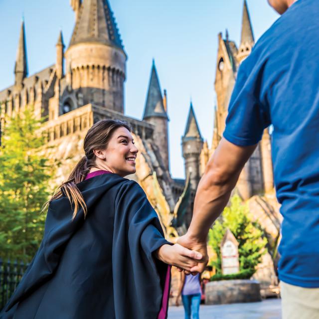 Couple at the Wizarding World of Harry Potter Hogsmeade at Universal's Islands of Adventure with Hogswarts Castle in the background