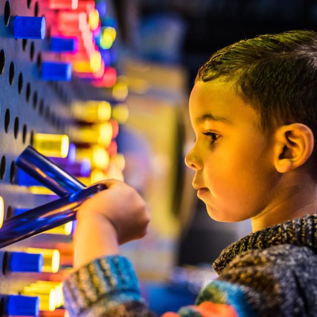 A child playing with the oversized Lite Brite wall at Wonderworks in Orlando.