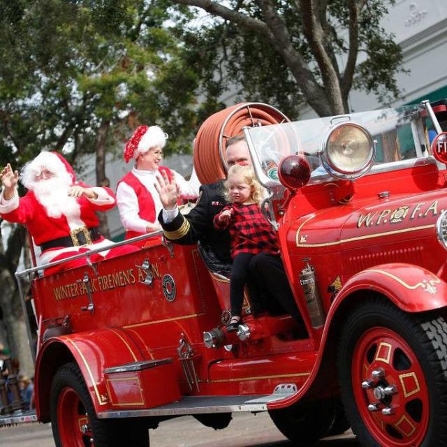 Santa rides a fire truck in the Winter Park Christmas Parade