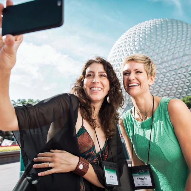 Two women taking a selfie in front of Spaceship Earth at Epcot