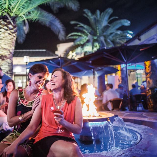 Two women enjoying cocktails outside at Blue Martini