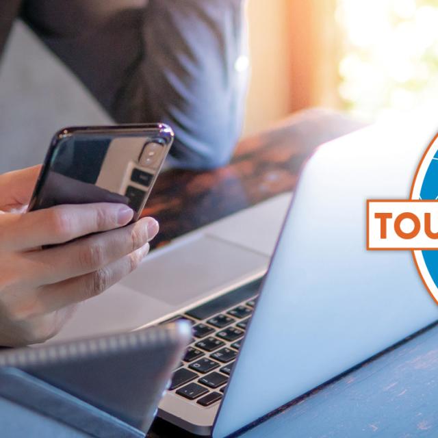 A man holding a cell phone in front of a laptop, with a Visit Orlando Tourism Help Hub logo layered over top.