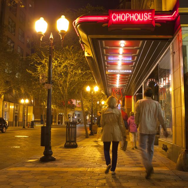 people walking by Kres restaurant at Church Street Station in downtown Orlando at night