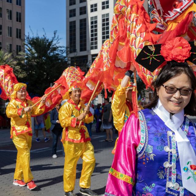 A woman poses in front of participants in the FusionFest parade.