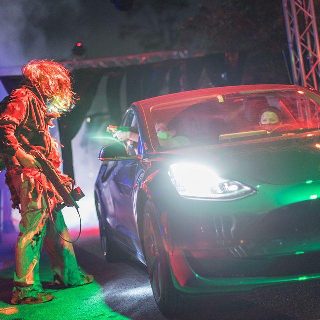 A zombie approaches a vehicle as it drives through Scream 'n' Stream, a Halloween attraction in Orlando.