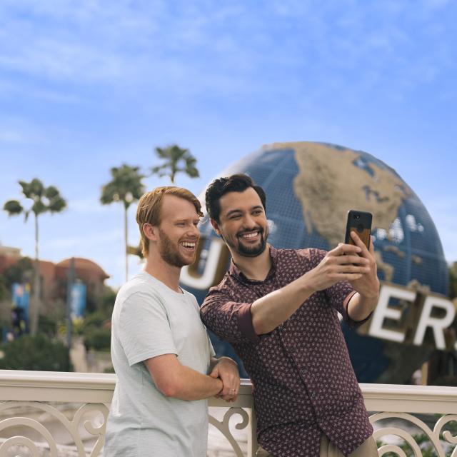gay couple taking selfie at universal studios globe