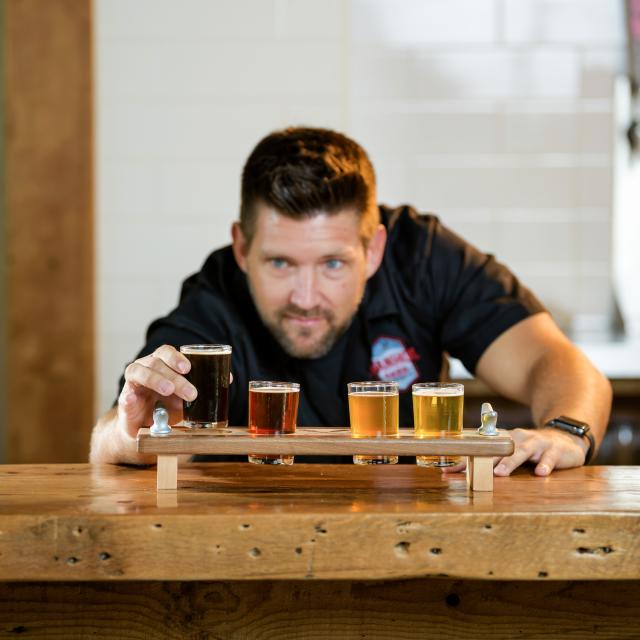 Bartender with a flight of beer at Ivanhoe Park Brewing Co.