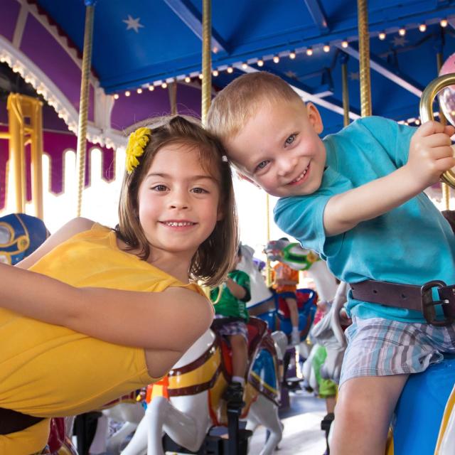 two children riding on a carousel