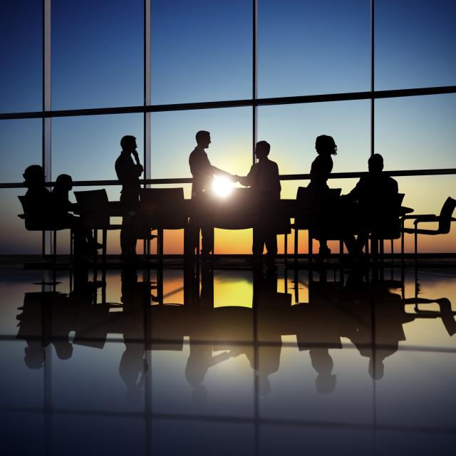 silhouette of business people meeting with the sun shining in the background