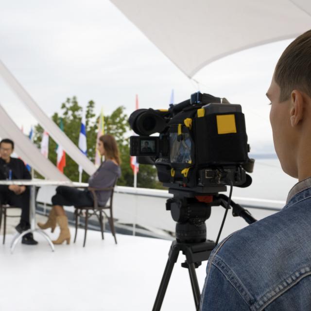 A camera operator filming an interview
