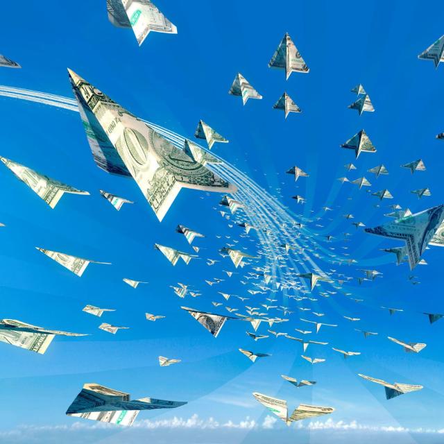 Paper airplanes made of dollar bills flying in a blue sky