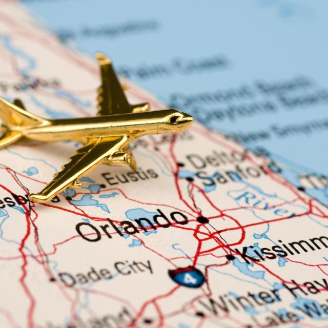 gold airplane laying on top of a map of florida