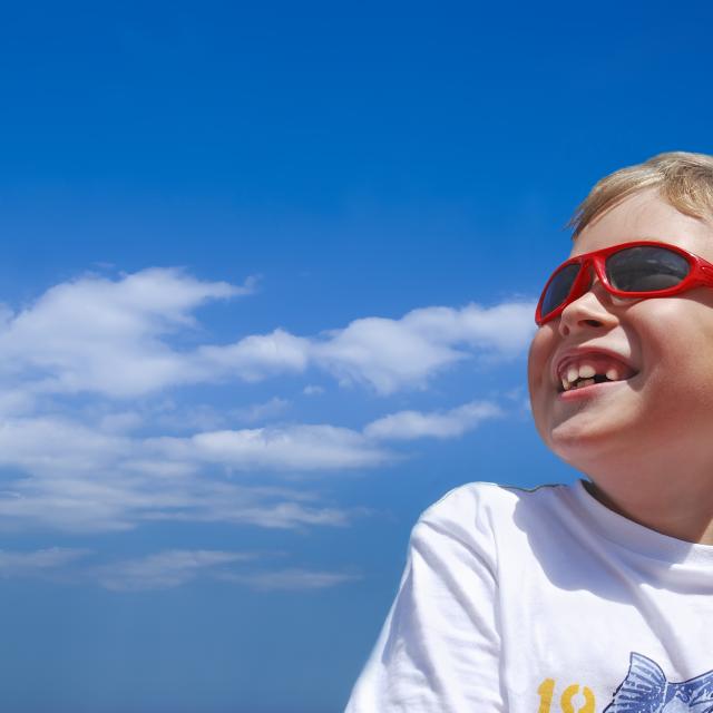 a young boy wearing sunglasses and smiling