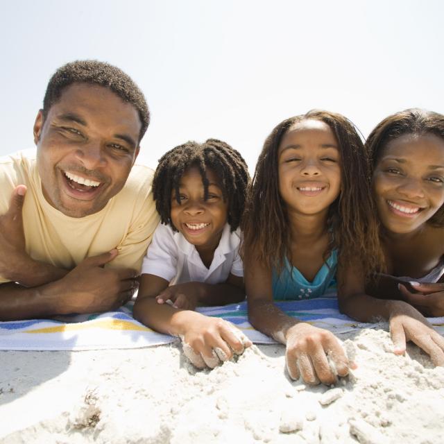 African-American family laying on a towel at the beach