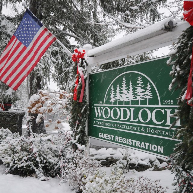 A snow-covered Woodloch Guest Registration Sign in the Pocono Mountains.