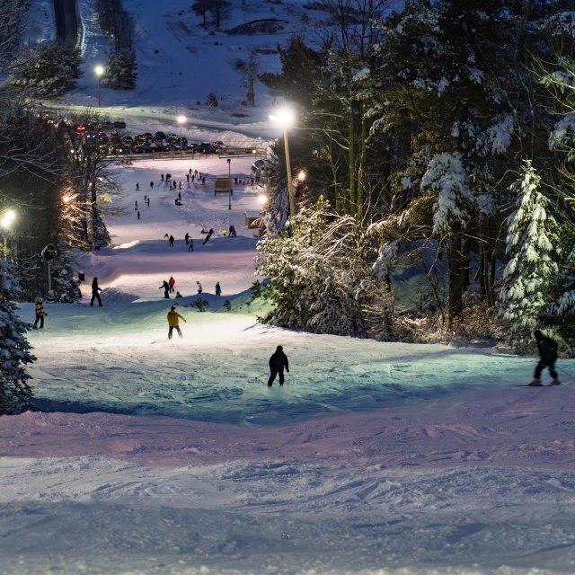 A group skiing at nighttime on the slopes
