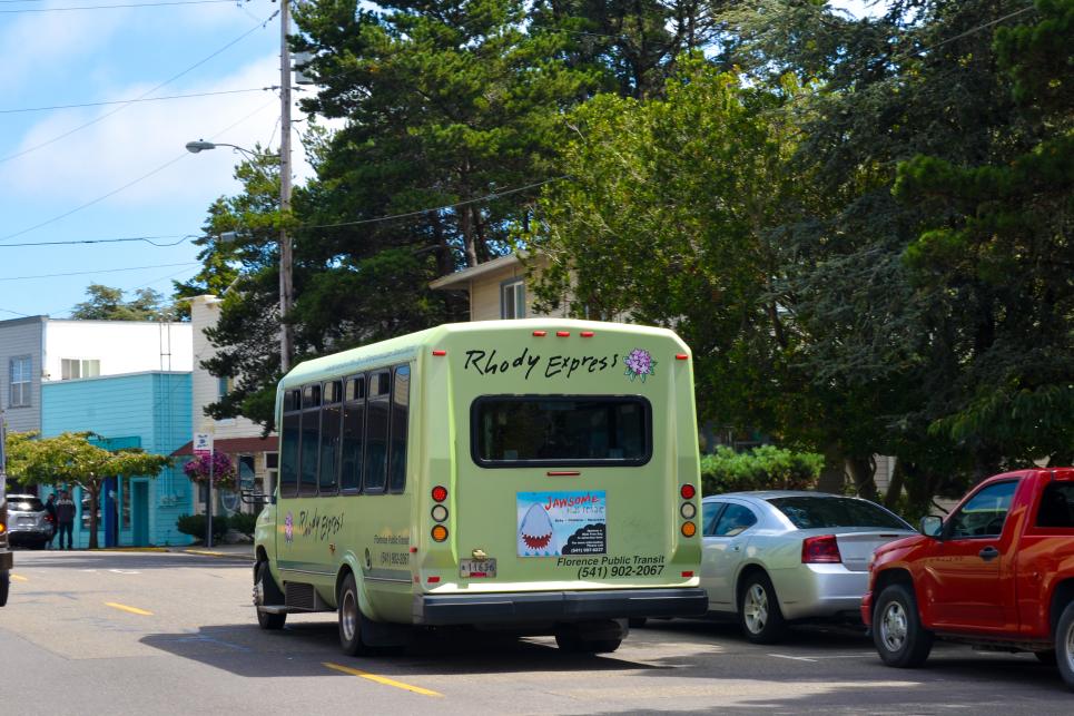 A small green bus painted with the words Rhody Express.