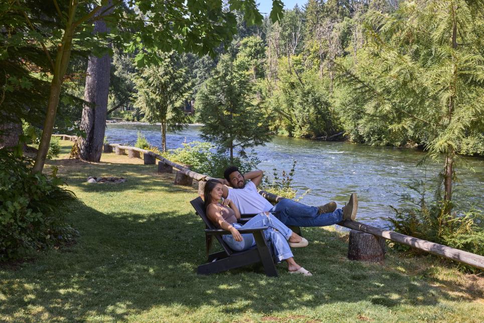Two people relax by the river.