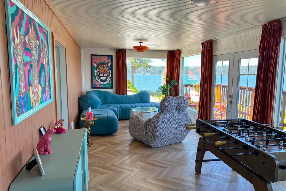 Funky couches and tables in cool, modern shapes, a foosball table and bright psychedelic paintings furnish the room overlooking the lake.