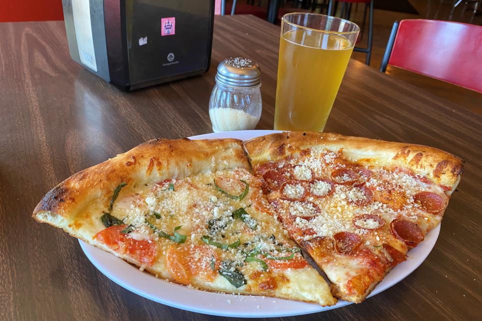 Two slices of pizza on a plate - one veggie and one pepperoni.