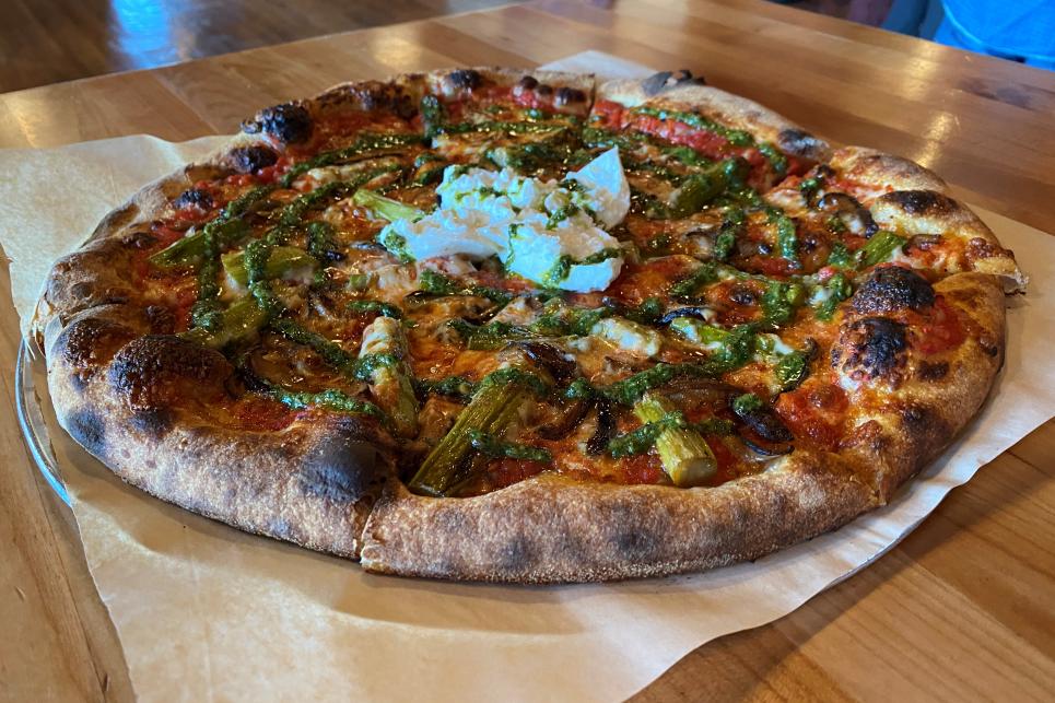A woodfired pizza on a the table.