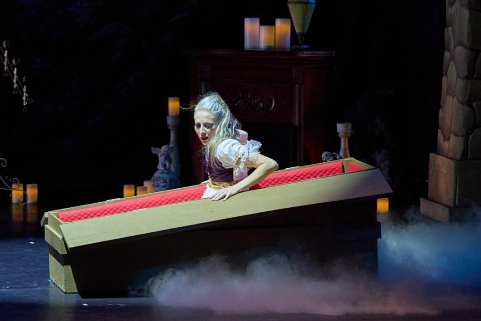 A dancer emerges from a coffin on stage.
